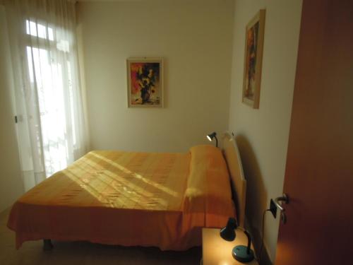 un dormitorio con una cama y una ventana en Homely 1 bedroom flat with side sea view, en Bibione