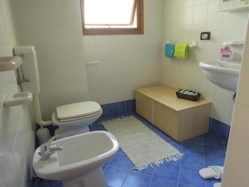 un baño con inodoro y lavabo en Homely 1 bedroom flat with side sea view, en Bibione