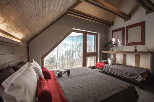 1 Schlafzimmer mit 2 Betten und einem großen Fenster in der Unterkunft Aspen Deluxe Residence & ASPEN cottage in Mienzebrosche