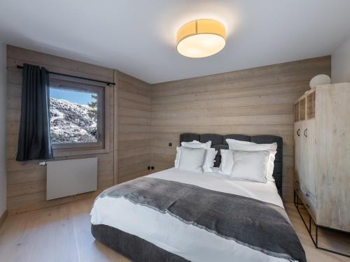 une chambre avec un grand lit et une fenêtre dans l'établissement Appartement Moderne avec Cheminée, Balcon Sud et Proche Télésiège à Méribel - FR-1-565-62, à Les Allues