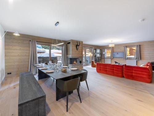 - une salle à manger avec une table et un canapé rouge dans l'établissement Appartement moderne avec cheminée et terrasse - Près des pistes et commerces - FR-1-565-63, à Les Allues