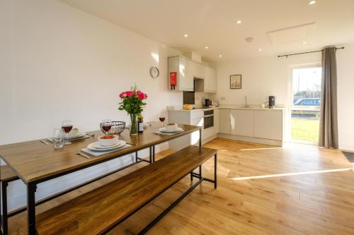 a kitchen and living room with a wooden table at Three Tuns - Garden Suite 3 in Wickham Market