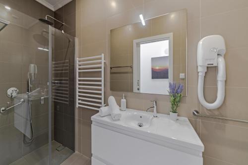 La salle de bains est pourvue d'un lavabo, d'une douche et d'un miroir. dans l'établissement Stunning Funchal Villa - 3 Bedrooms - Vila da Portada - Panoramic Sea Views - Recently Refurbished, à Funchal