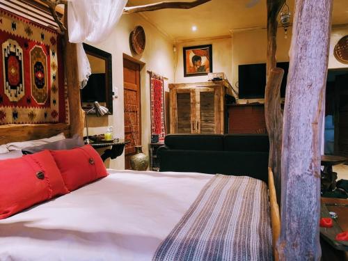1 dormitorio con 1 cama blanca grande con almohadas rojas en Frieden-Hof Guest Accommodation, en Penhill