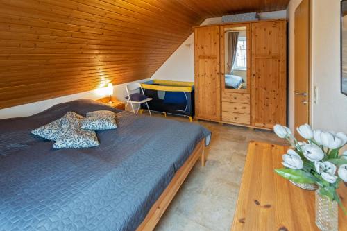 1 dormitorio con 1 cama y pared de madera en Ferienhaus Strandläufer, en Nessmersiel