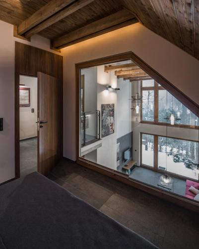 a bedroom with a large window and a large bed at Aspen Deluxe Residence & ASPEN cottage in Międzybrodzie Bialskie