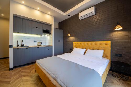 a bedroom with a large white bed and a kitchen at Idea Design Apart-Hotel Prorizna in Kyiv