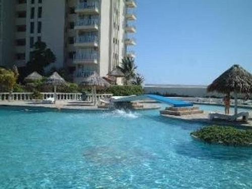a swimming pool with blue water in front of a building at Ocean View Room 1202near The Clubs in Cancún