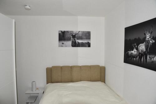 a bedroom with a bed with a picture of deer on the wall at Appartement Wolf Nummer 69 in Baiersbronn