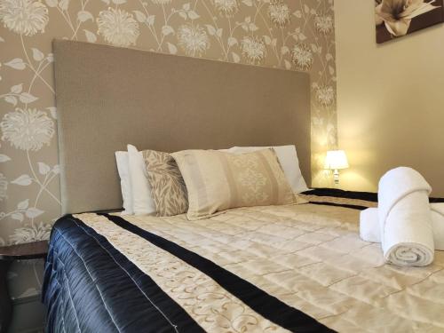 a bedroom with a large bed with a large headboard at Kirkhill Estate Rooms in Gorebridge