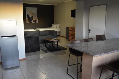 a kitchen and living room with a couch and a table at Quiver Inn Guesthouse in Keetmanshoop