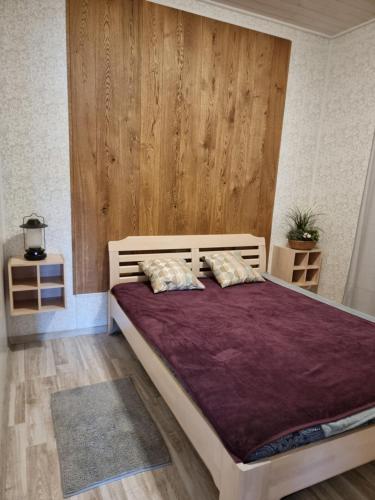 1 dormitorio con 1 cama grande con sábanas moradas en Houseboat "Upes Nams" en Varkaļi