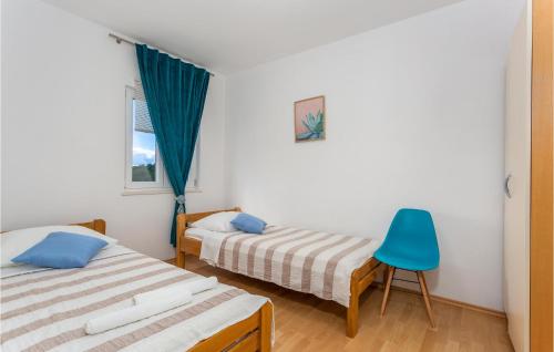 a bedroom with two beds and a blue chair at 2 Bedroom Beautiful Apartment In Pinezici in Pinezici