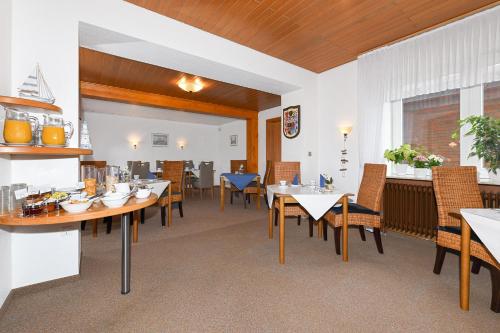 a dining room with tables and chairs at Hotel-Pension Marlies in Neuharlingersiel