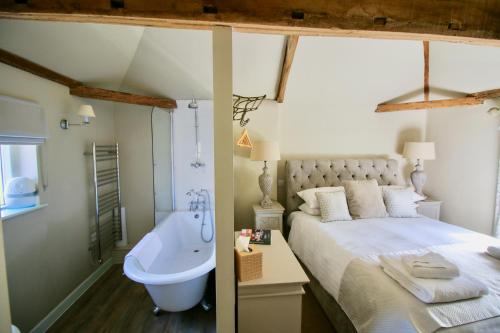 a bedroom with a large bed and a bath tub at Kings Head Bawburgh in Norwich