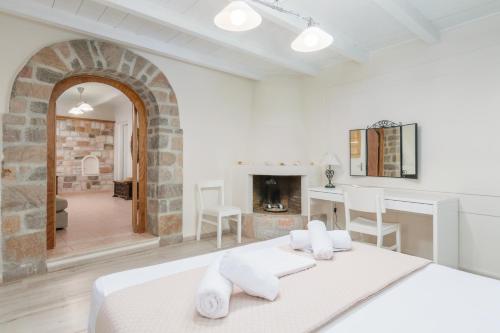 Dormitorio blanco con cama y chimenea en Lina and Babis' Home, en Adamas