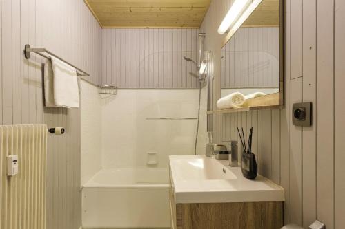 a white bathroom with a sink and a shower at Residence de Lognan- Les Jorasses 27 - Happy Rentals in Chamonix