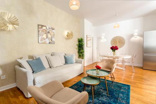 een woonkamer met een witte bank en een tafel bij Cosy 3 Bedroom 1 bathroom - Champs Elysees in Parijs