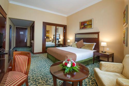 a hotel room with a bed and a living room at Concorde Hotel Fujairah in Fujairah