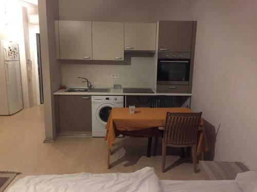 cocina con mesa, fregadero y lavadora en Private Room in Istanbul #32, en Estambul