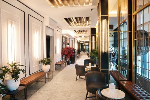 a corridor of a building with benches and tables at H&oacute;tel Reykjav&iacute;k Saga in Reykjav&iacute;k