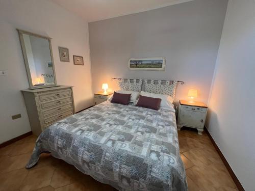 ein Schlafzimmer mit einem Bett und zwei Nachttischen und zwei Lampen in der Unterkunft Casa vacanze La Via del Mare in Scanzano