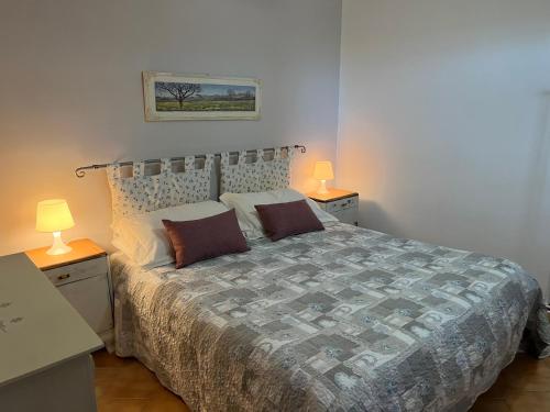 ein Schlafzimmer mit einem Bett mit zwei Nachttischen und zwei Lampen in der Unterkunft Casa vacanze La Via del Mare in Scanzano