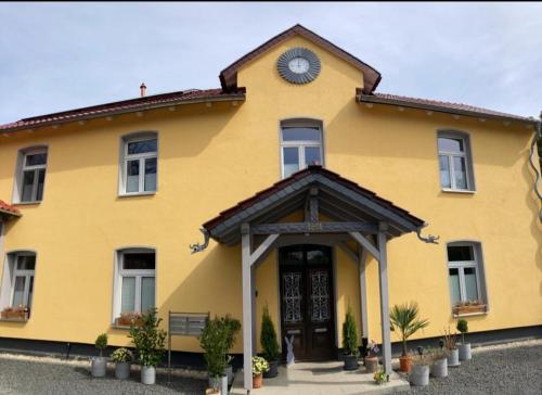 a yellow building with a clock on top of it at Haus Eveline - Ferienwohnungen unterhalb der Wartburg - in Eisenach