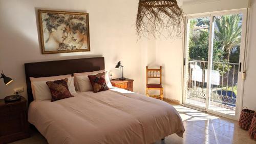 - une chambre avec un lit et une porte coulissante en verre dans l'établissement Casa Moraleda I Vivienda Rural, à Pinos del Valle