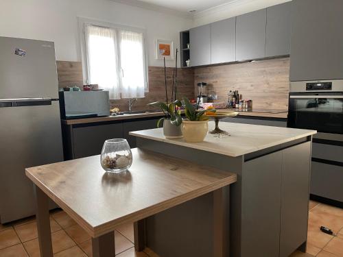 a kitchen with a table with a wine glass on it at Confortable villa de vacances entre Nîmes, le Pont du Gard, Uzès, Arles, Avignon in Marguerittes