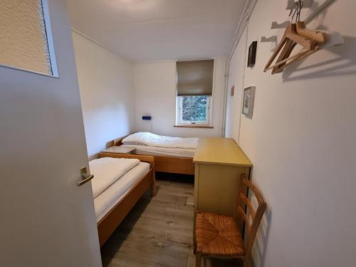a small room with two beds and a window at Zilt Zand in De Koog
