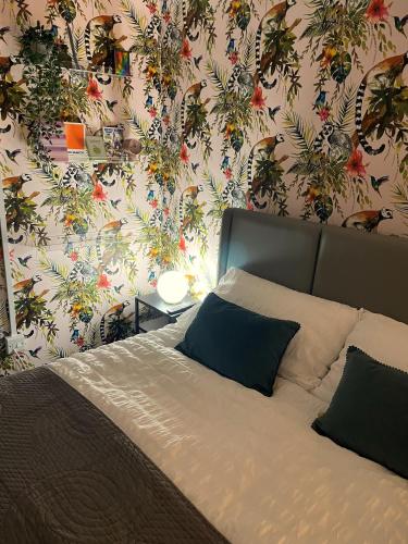 a bedroom with a bed with a floral wallpaper at Modern studio apartment; 10min walk to town & quay in Exeter