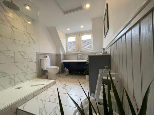 a bathroom with a tub and a toilet and a sink at Rural Country Suites - Judge's Lodge in East Grinstead