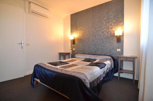 um quarto com duas camas e duas mesas em Brit Hotel Cahors - Le Valentré em Cahors