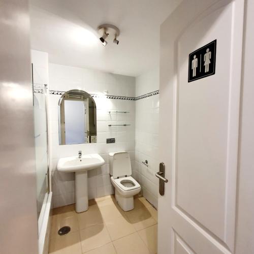 La salle de bains blanche est pourvue de toilettes et d'un lavabo. dans l'établissement Penthouse in Reserva de Marbella, à Marbella