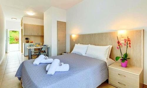 a bedroom with a large bed with towels on it at Fodele Beachfront Apts, Βy IdealStay Experience in Fodele