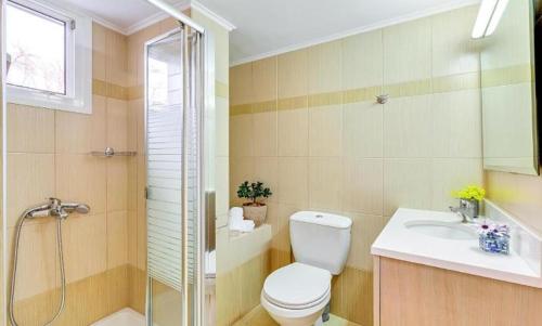 een badkamer met een toilet, een douche en een wastafel bij Fodele Beachfront Apts, Βy IdealStay Experience in Fodele