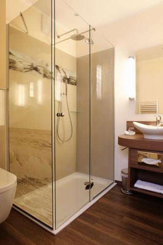 a bathroom with a shower and a toilet and a sink at Hotel Simonshof in Wolfsburg