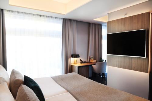 a hotel room with a bed and a flat screen tv at Hotel Reykjavík Saga in Reykjavík