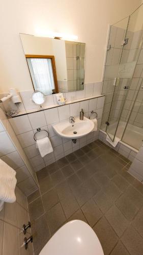 un baño con inodoro, lavabo y espejo en Hotel Cristobal, en Hamburgo