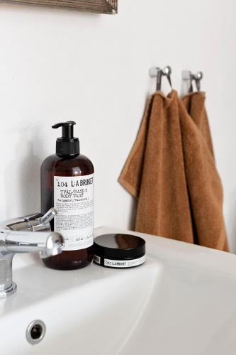 a bottle of loz ion bathroom soap sitting on a sink at Gartnerhuset på Kollerup in Hadsten Stationsby