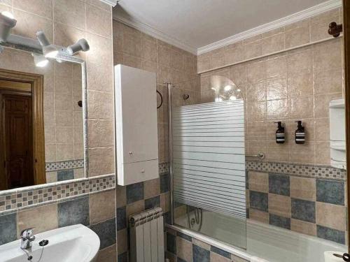 y baño con lavabo, bañera y espejo. en El Sobrao de Gredos, en Navarredonda de Gredos