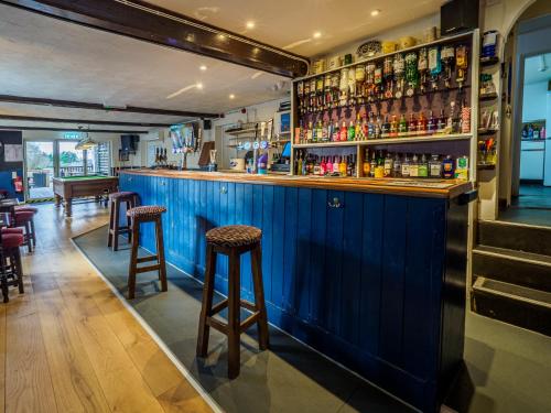 a blue bar with stools in a restaurant at The Live and Let Live in Downham Market