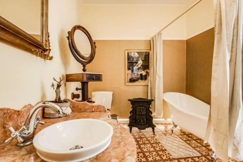 a bathroom with a sink and a tub and a mirror at LUXa Charm House by LovelyStay in Sintra