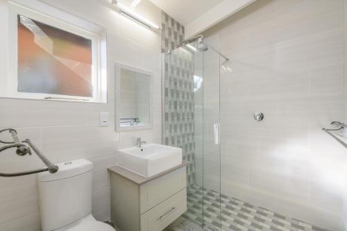 a white bathroom with a toilet and a sink at San Lameer Villa 3314 - 2 Bedroom Superior - 4 pax - San Lameer Rental Agency in Southbroom