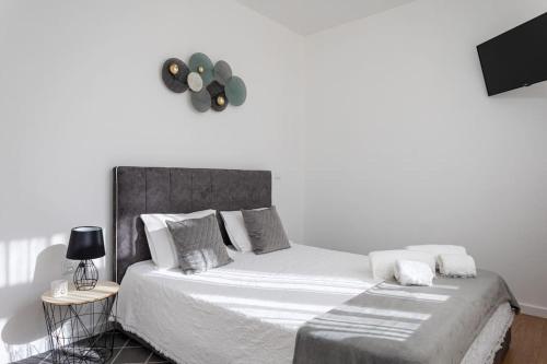 1 dormitorio con 1 cama grande con sábanas y almohadas blancas en Apartamento novo e acolhedor na Praia da Barra, en Gafanha da Nazaré