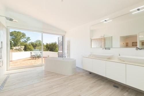 Baño blanco con 2 lavabos y espejo grande en Villa Penina, en Alvor