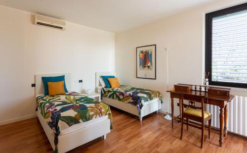 1 dormitorio con 2 camas, escritorio y ventana en Villa degli Angeli, en Soiano del Lago