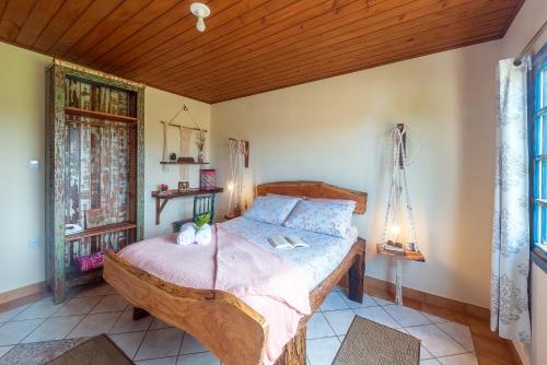 a bedroom with a large wooden bed in a room at Apartamentos exclusivos e equipado com varanda ou terraço com Pôr do sol, cozinha privativa, Wi-Fi 600MBs, a 700m da praia de Itapirubá e 1km da BR-101 in Imbituba