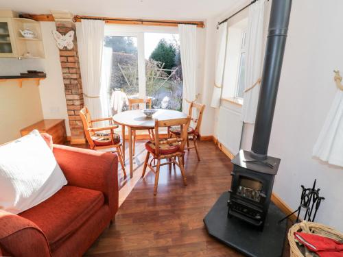 a living room with a wood stove and a table at The Orangery in Worcester